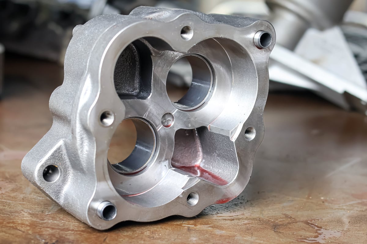 Precision-machined metal component on a workbench during inspection in a manufacturing facility