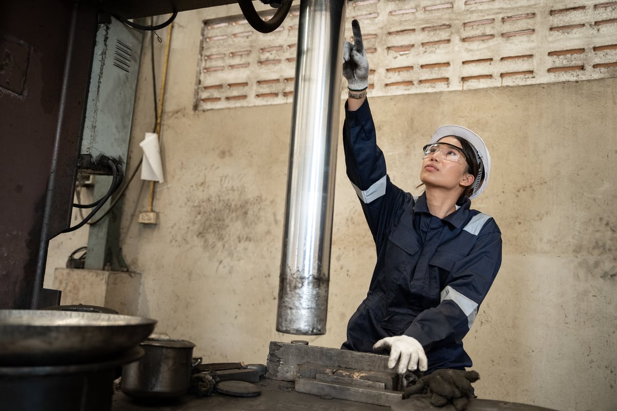 Engineer checking and controlling machine output in a production facility
