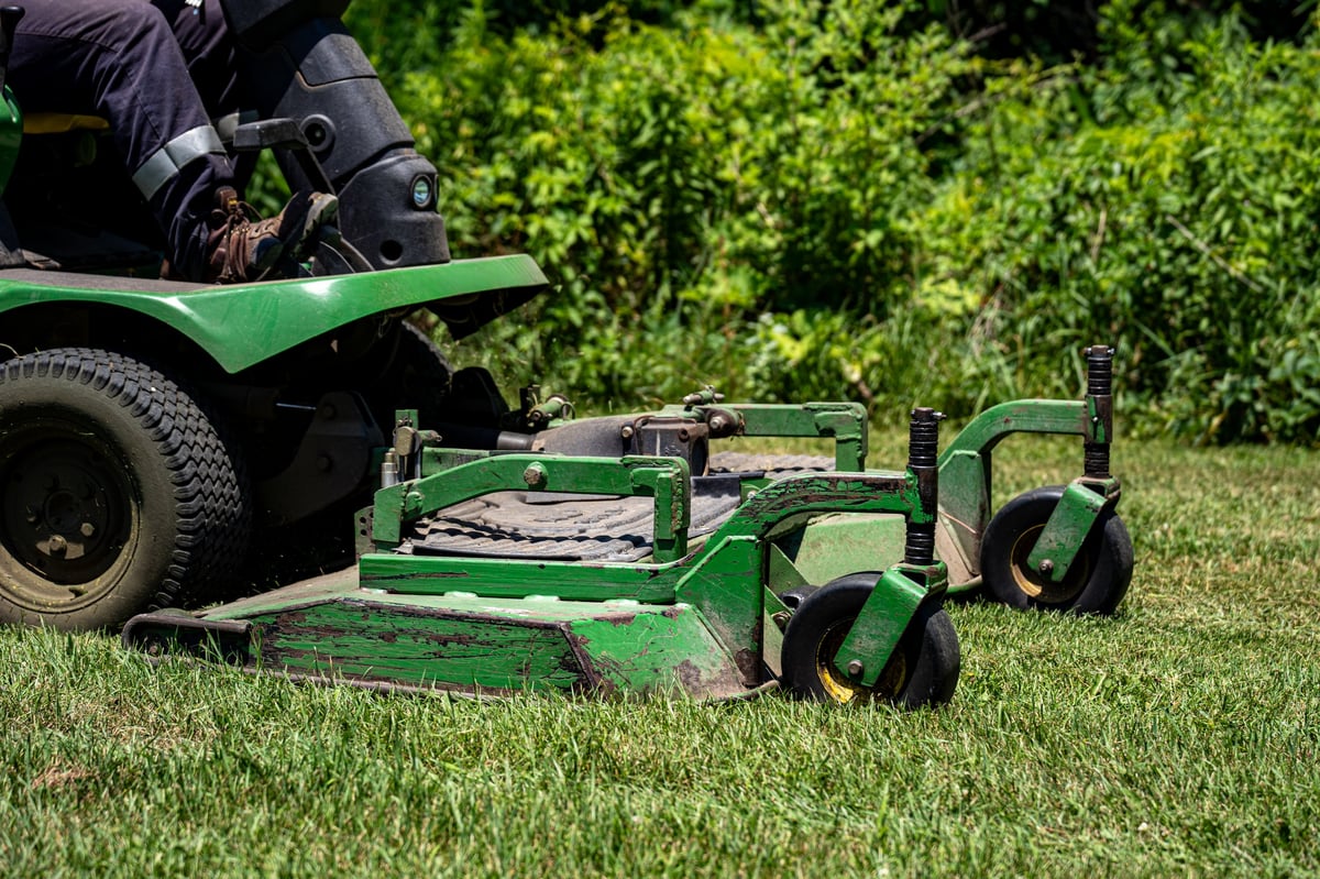 Close-up of a riding lawn mower cutting grass on a lawn
